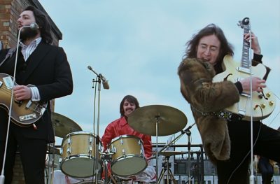 Beatles Get Back John Lennon rooftop guitar raised